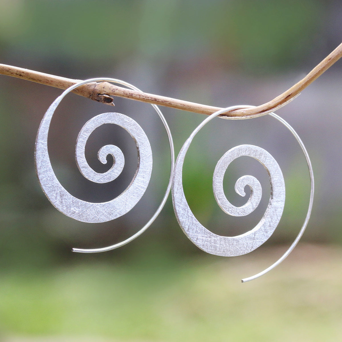 A Pair of Spiral-Shaped Half-Hoop Earrings in Silver