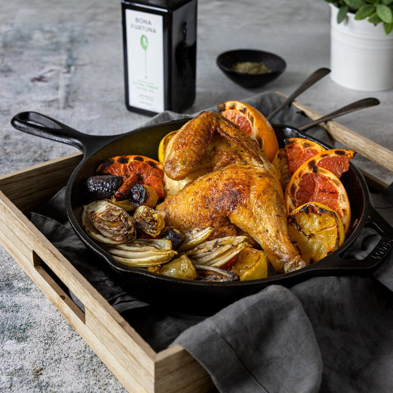 Pan of chicken and sides with oil bottle in background