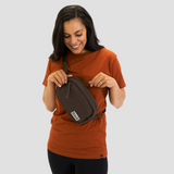 Female model wears sustainable organic cotton fanny pack styled as a shoulder sling bag