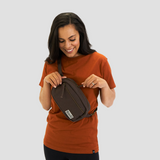 Female model wears sustainable organic cotton fanny pack styled as a shoulder sling bag
